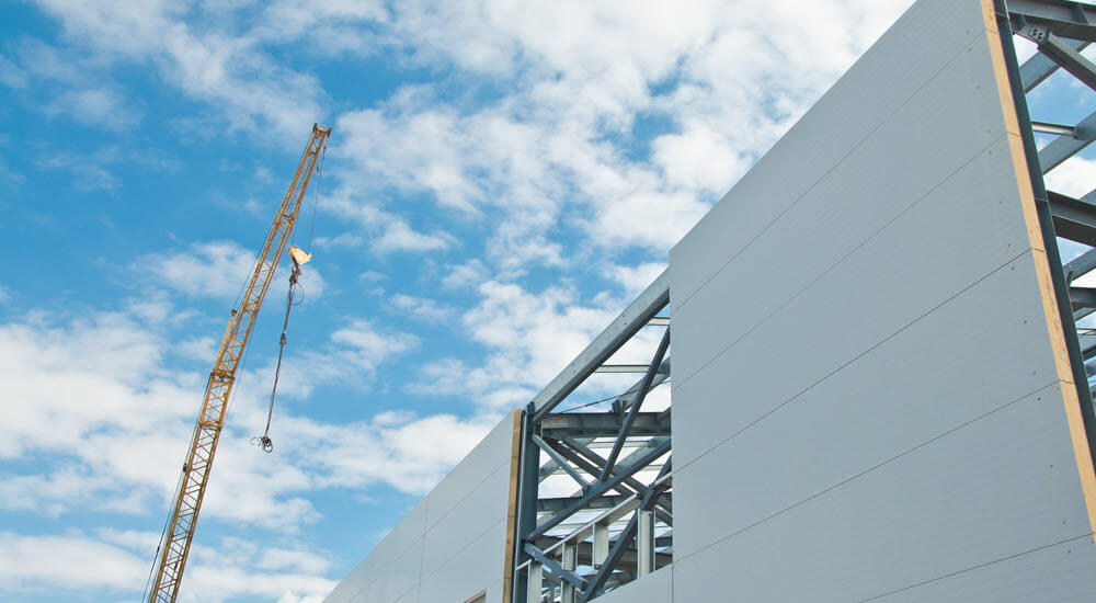 Metal frame of the building with a sandwich panel of insulation on the wall.